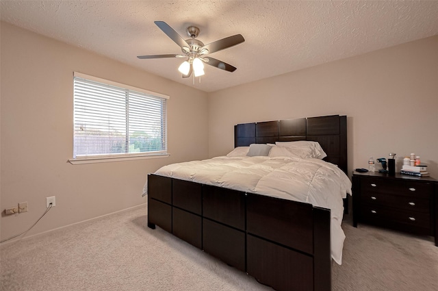 bedroom featuring light carpet, a textured ceiling, and a ceiling fan