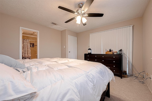 bedroom featuring a ceiling fan, light colored carpet, visible vents, and a textured ceiling