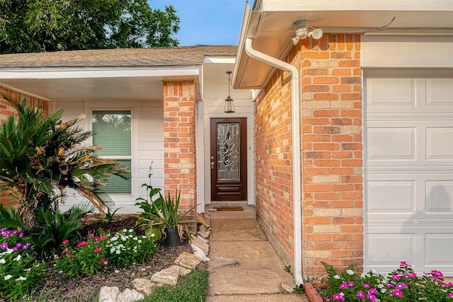 entrance to property with brick siding and a shingled roof