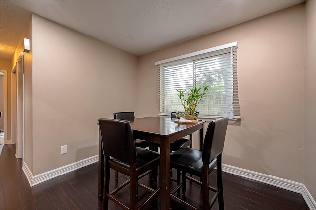 dining room with dark wood finished floors and baseboards