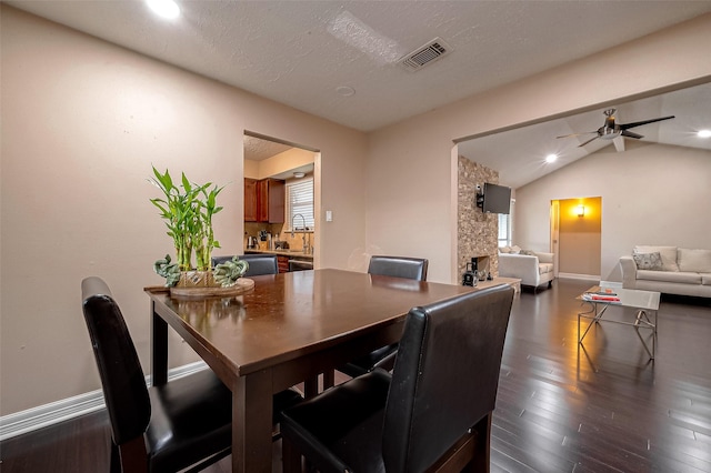 dining space with visible vents, dark wood-style floors, baseboards, ceiling fan, and vaulted ceiling