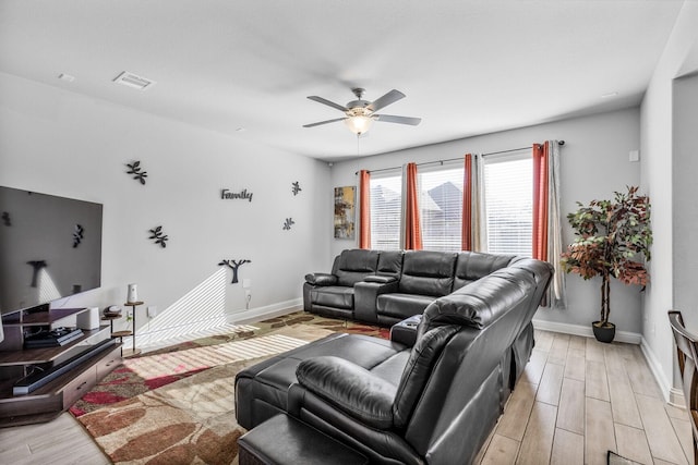 living area featuring light wood-type flooring, visible vents, baseboards, and ceiling fan