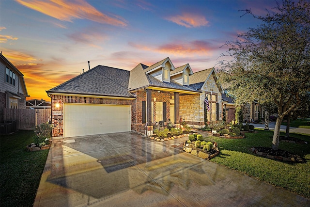 view of front of property featuring fence, driveway, a yard, a shingled roof, and a garage