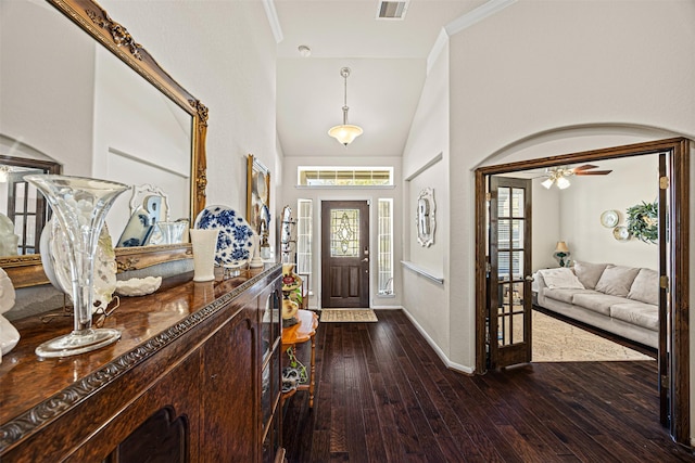 entrance foyer featuring visible vents, baseboards, ornamental molding, and dark wood-style flooring