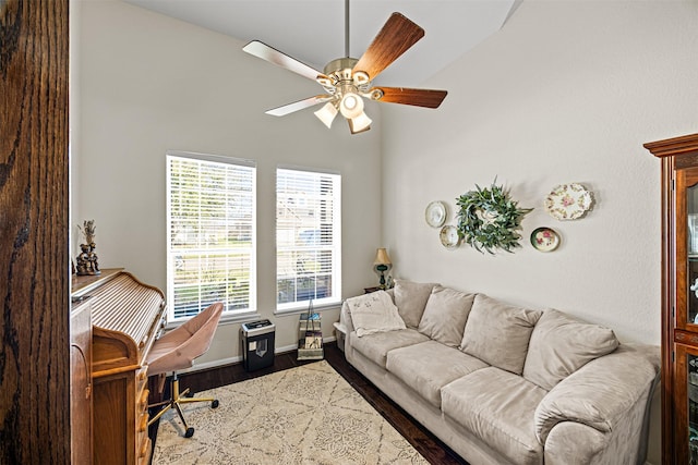 office featuring dark wood-type flooring, a ceiling fan, and baseboards