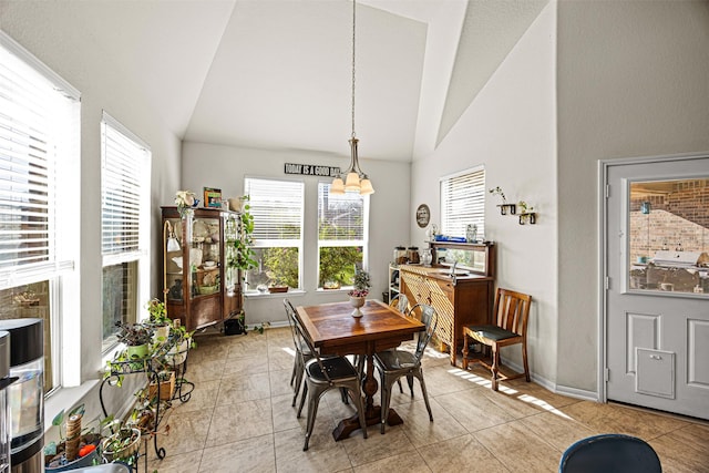 dining area with light tile patterned flooring, baseboards, and lofted ceiling