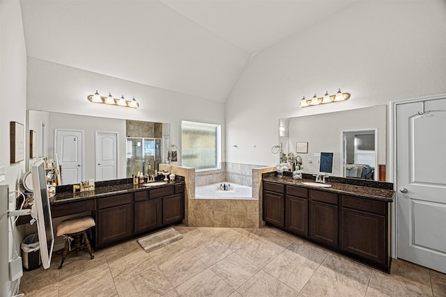 full bathroom with two vanities, a bath, a shower stall, and vaulted ceiling