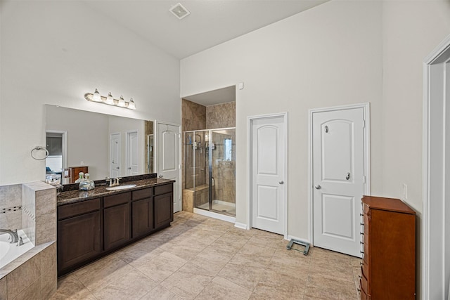 full bathroom with visible vents, a stall shower, a high ceiling, a bath, and vanity