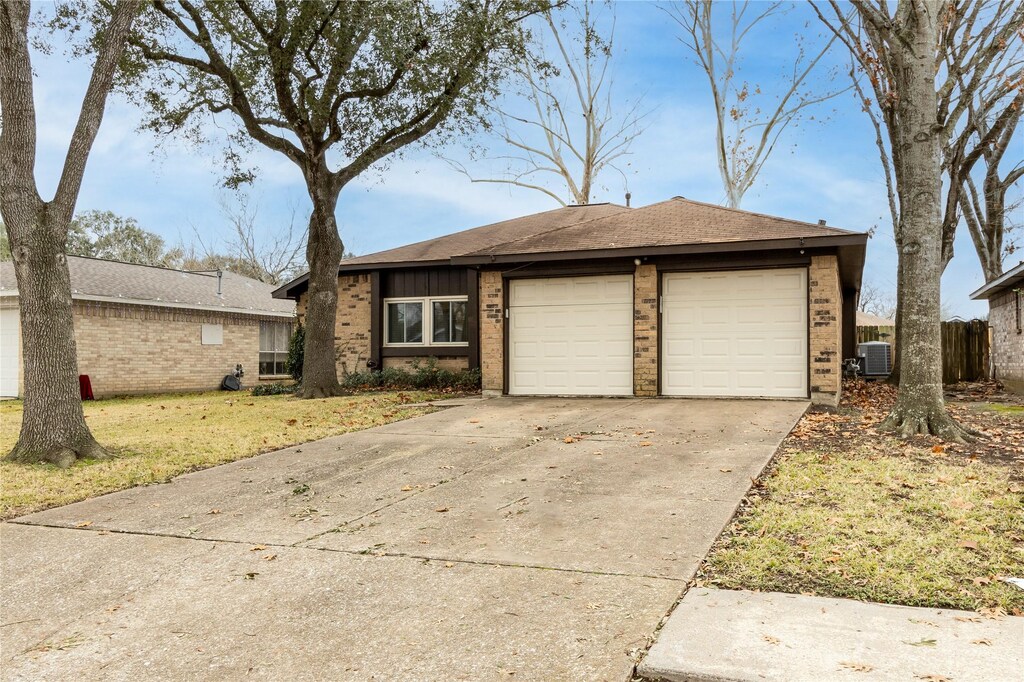 430 Village Creek Dr, Houston, TX 77598 - ranch-style home featuring brick siding, fence, cooling unit, driveway, and an attached garage