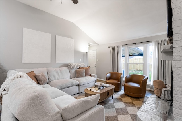 living area featuring baseboards, a ceiling fan, and lofted ceiling