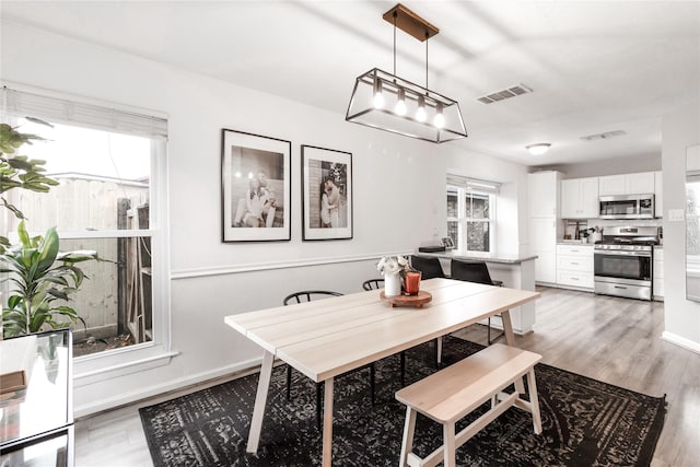 dining area with visible vents, plenty of natural light, light wood-style flooring, and baseboards