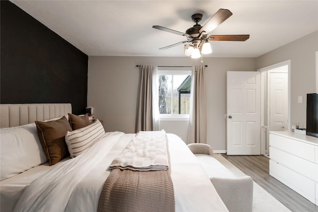 bedroom with light wood-style flooring, baseboards, and ceiling fan