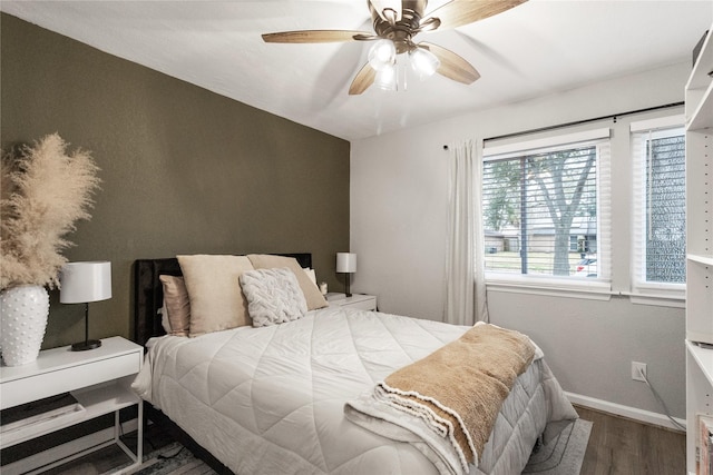 bedroom with a ceiling fan, baseboards, and wood finished floors