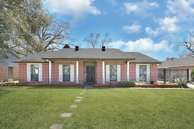 view of front facade featuring brick siding, a front yard, and roof with shingles