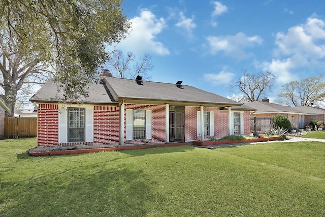 ranch-style home with brick siding, a chimney, a front yard, and fence