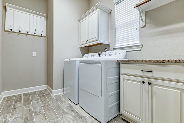 laundry area with baseboards, cabinet space, wood tiled floor, and washing machine and clothes dryer