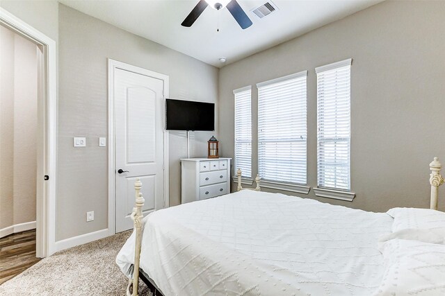 carpeted bedroom featuring a ceiling fan, baseboards, and visible vents