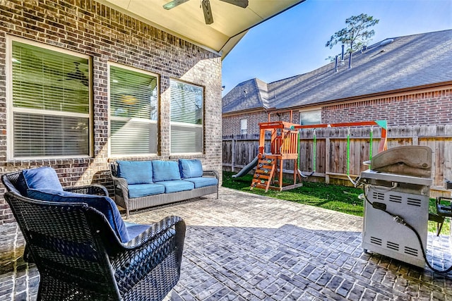 view of patio / terrace with outdoor lounge area, a playground, a fenced backyard, and a ceiling fan