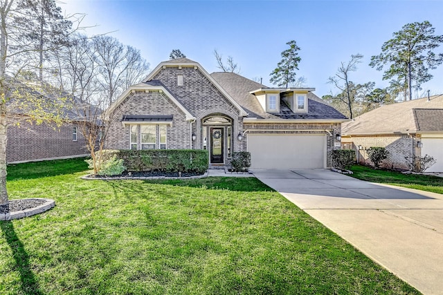 french country inspired facade with a front lawn, concrete driveway, a shingled roof, a garage, and brick siding