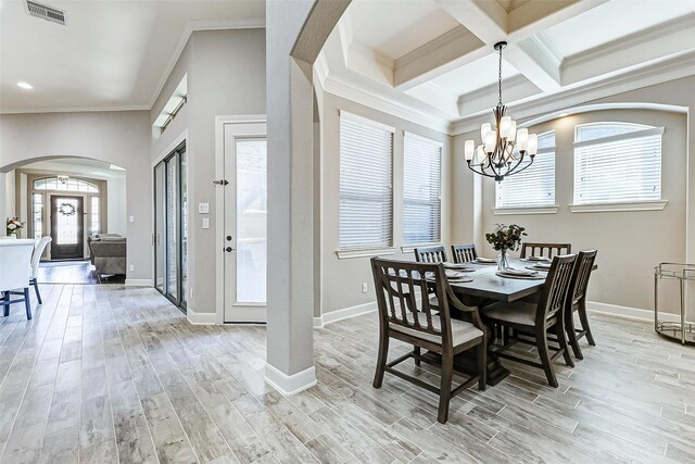 dining room featuring arched walkways, visible vents, light wood-type flooring, and a wealth of natural light