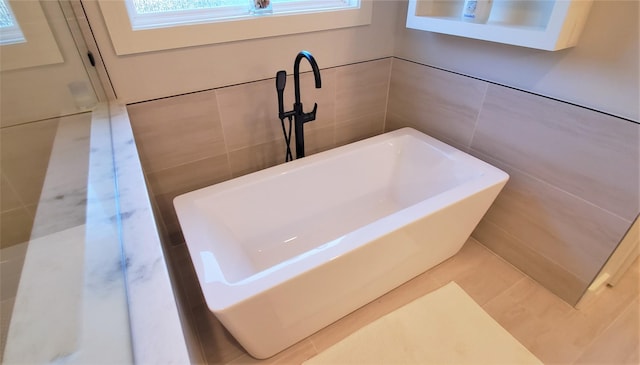 full bathroom with tile walls and a washtub