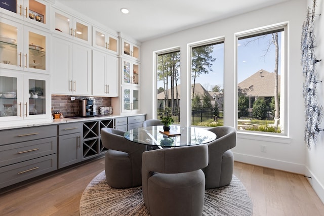 dining room with recessed lighting, wood finished floors, baseboards, and a wealth of natural light