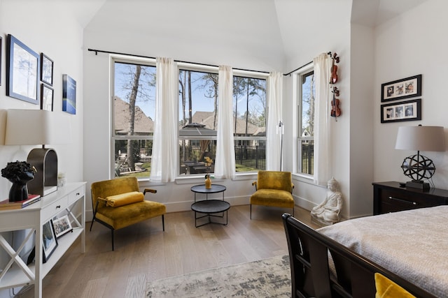 bedroom with baseboards, multiple windows, wood finished floors, and vaulted ceiling