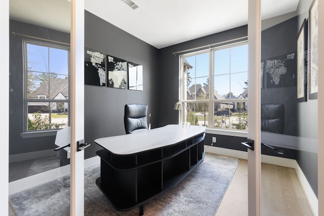 office area with a wealth of natural light, visible vents, and baseboards