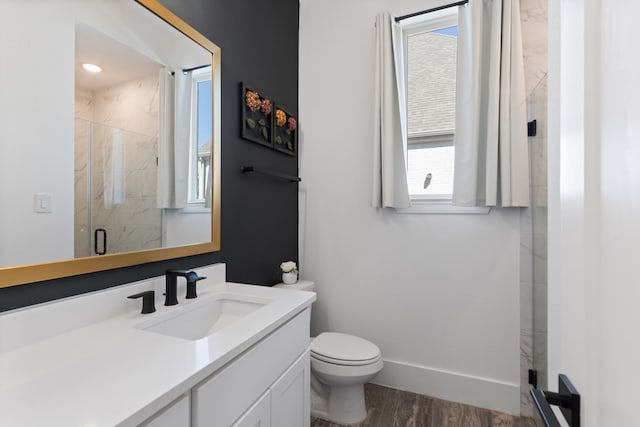 full bathroom with baseboards, toilet, a stall shower, wood finished floors, and vanity