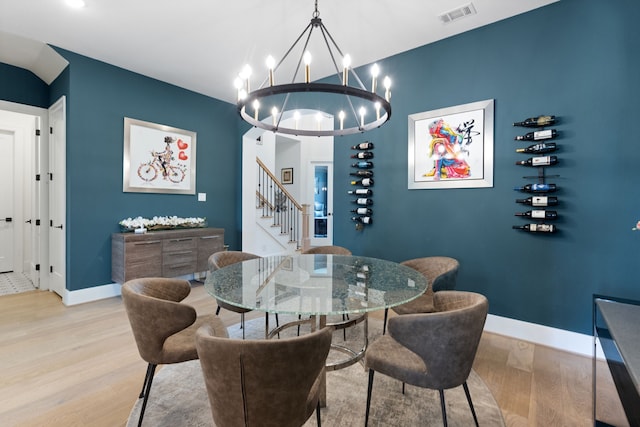 dining room with stairs, wood finished floors, visible vents, and baseboards