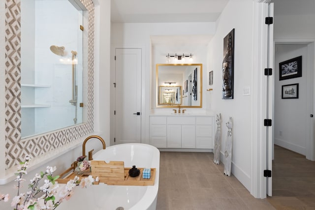 bathroom featuring vanity, baseboards, and a freestanding bath