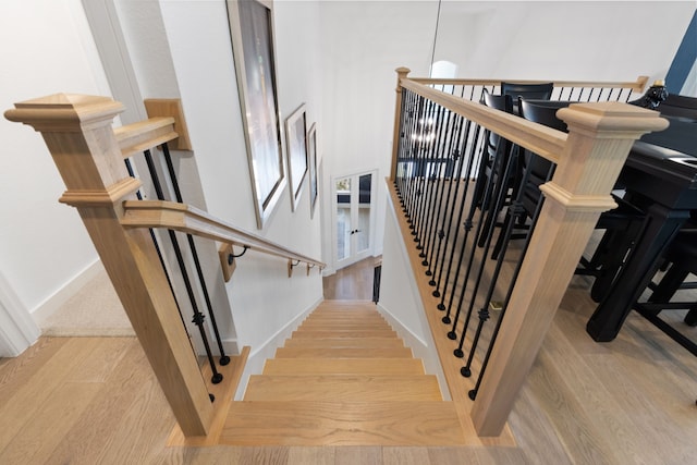 stairway with baseboards and wood finished floors