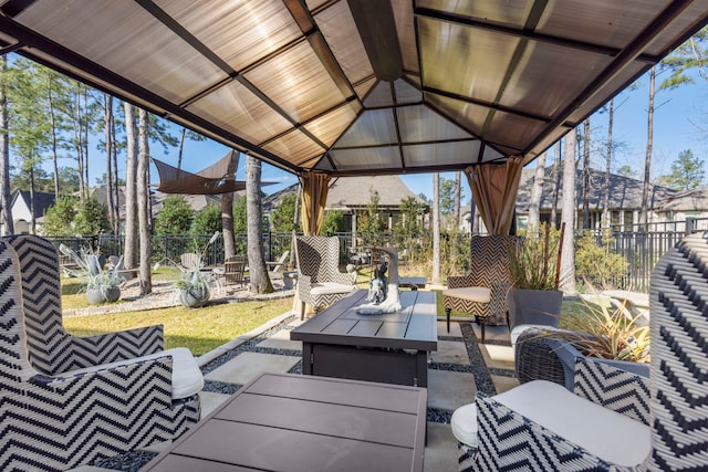 view of patio / terrace featuring a gazebo, an outdoor living space with a fire pit, and fence