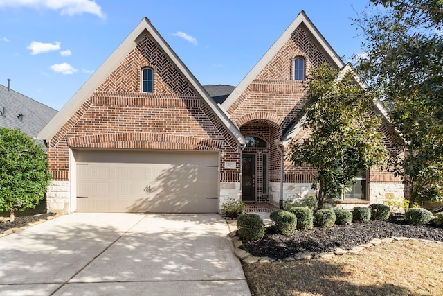 view of front of property with concrete driveway, a garage, brick siding, and stone siding