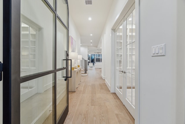 corridor with visible vents, recessed lighting, french doors, and light wood-type flooring