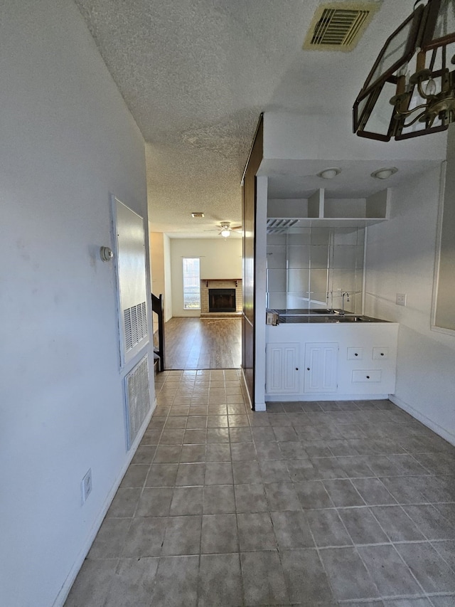 interior space featuring dark tile patterned floors, visible vents, and a textured ceiling