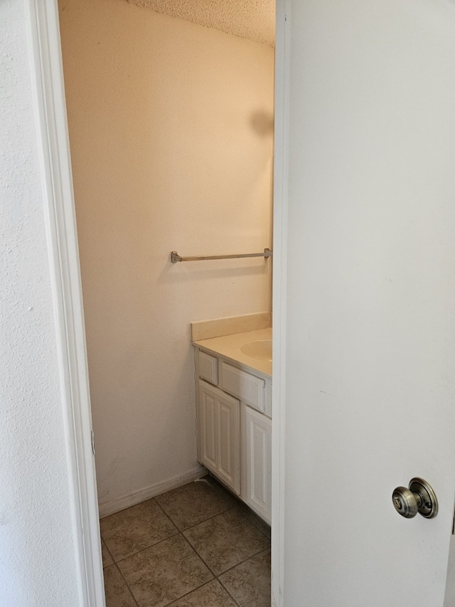 bathroom with vanity, tile patterned floors, and baseboards