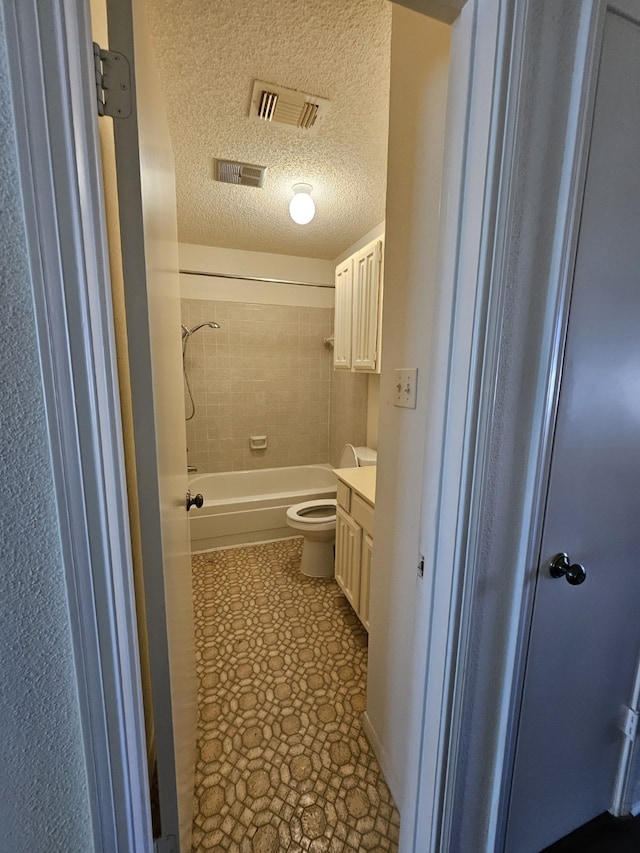 bathroom with visible vents, a textured ceiling, vanity, and toilet