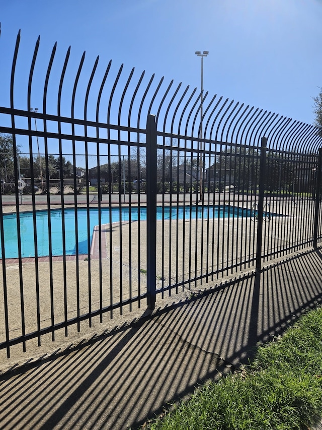 view of swimming pool featuring fence