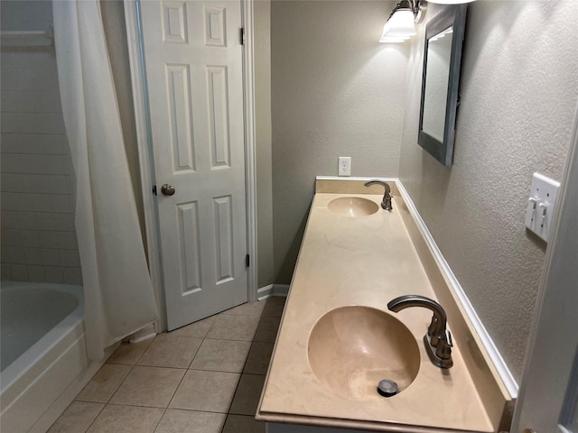 full bath featuring a sink, a textured wall, shower / tub combo, and tile patterned flooring