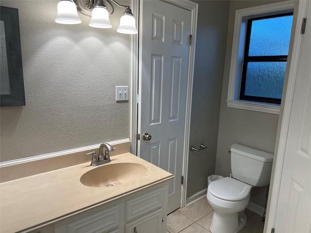 bathroom featuring tile patterned flooring, baseboards, toilet, a notable chandelier, and vanity