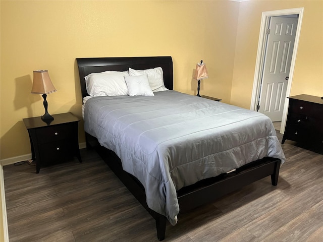 bedroom featuring wood finished floors and baseboards