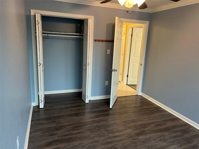 unfurnished bedroom featuring a ceiling fan, wood finished floors, a closet, crown molding, and baseboards