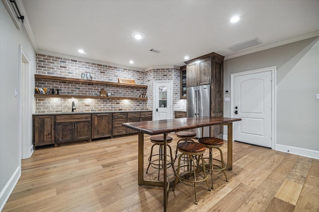 kitchen with light wood finished floors, open shelves, ornamental molding, dark brown cabinetry, and high quality fridge