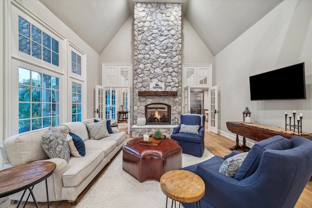 living area featuring baseboards, french doors, a fireplace, wood finished floors, and high vaulted ceiling