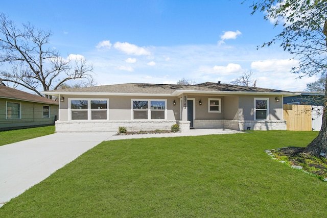 ranch-style home featuring a front lawn, fence, and stucco siding