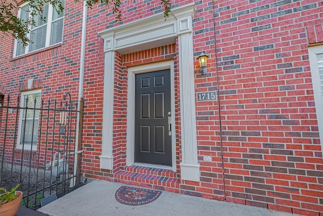 view of exterior entry featuring brick siding