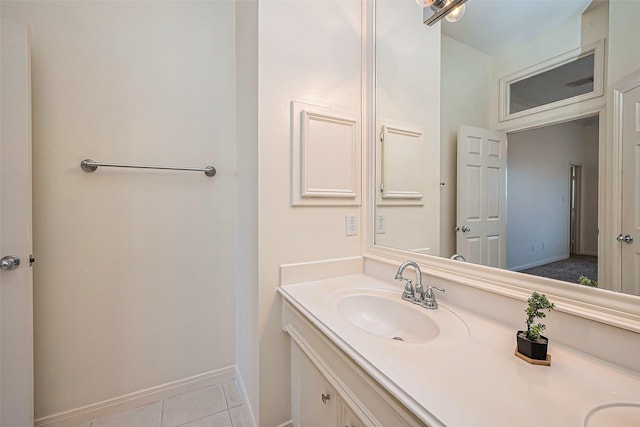 bathroom with baseboards, vanity, and tile patterned flooring