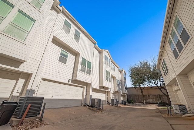 exterior space featuring central air condition unit, a residential view, and driveway