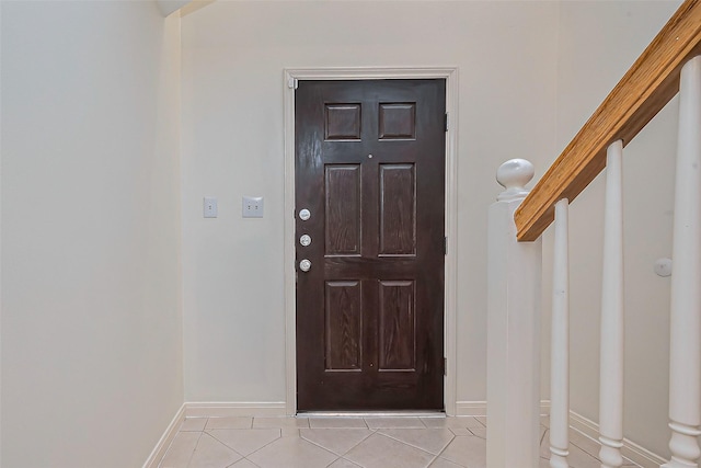 doorway to outside with baseboards, light tile patterned flooring, and stairs